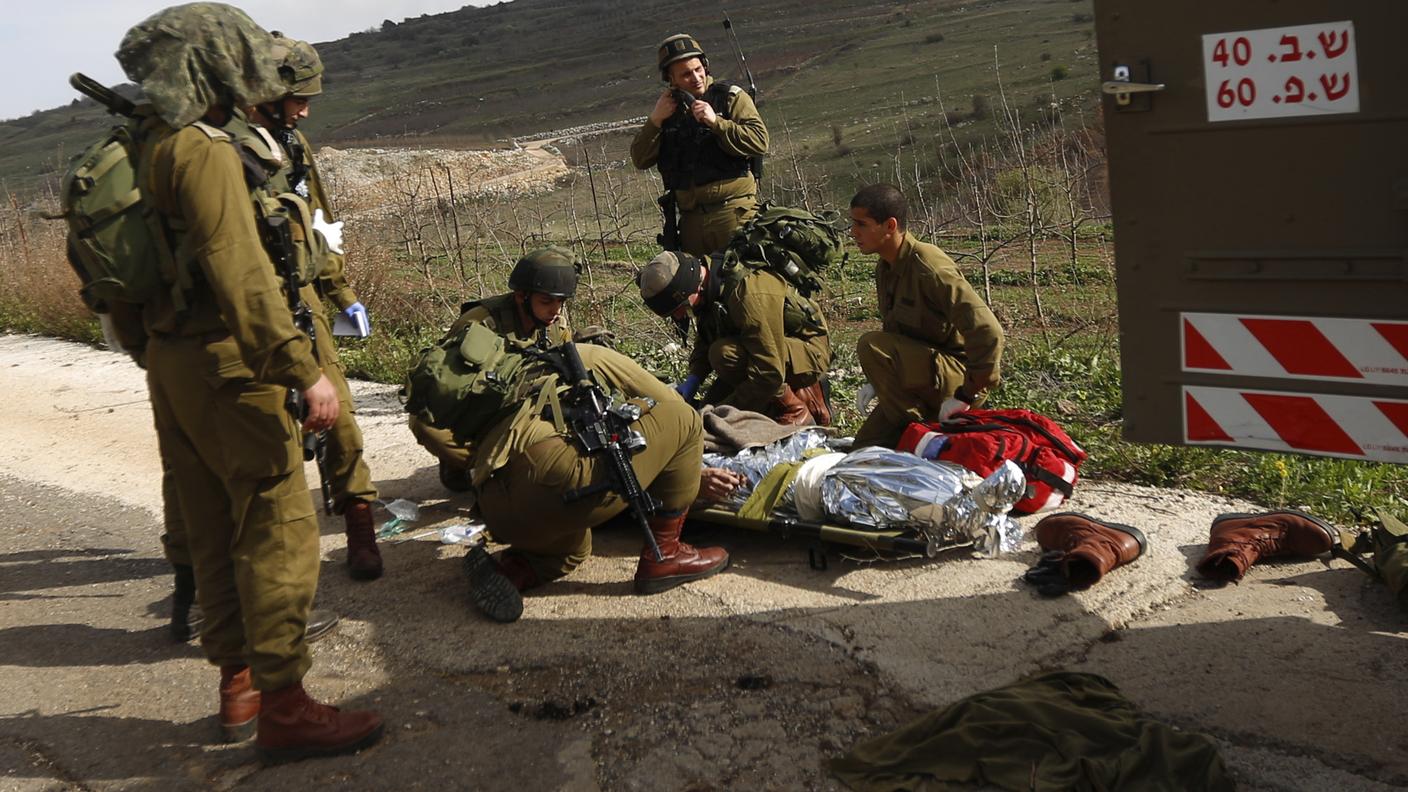Soldati israeliani assistono un compagno colpito sulle alture del Golan, martedì