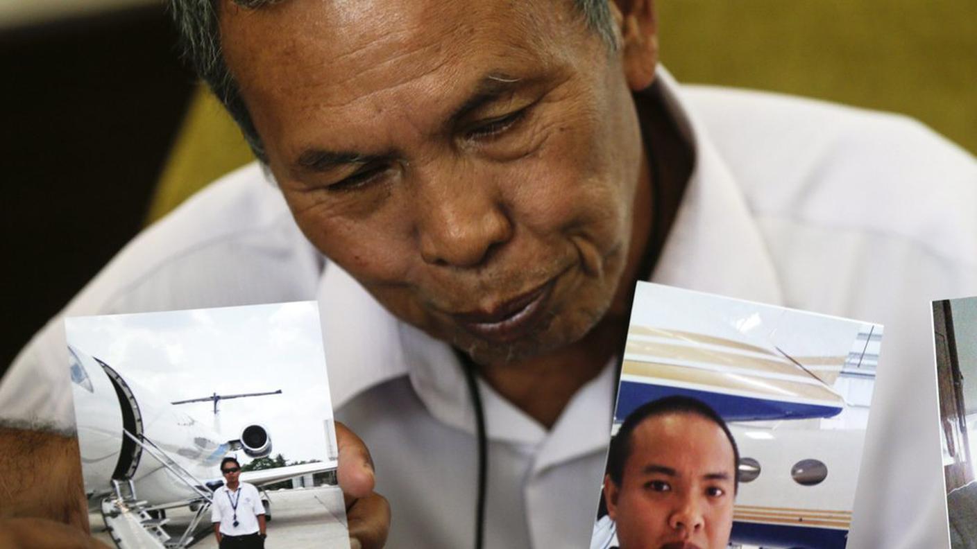 Il padre di Mohd Khairul Amri Selamat con due fotografie del figlio