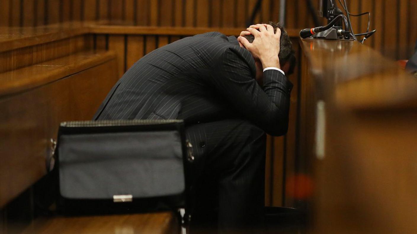 Il 27enne imputato, con le mani dietro la testa e un secchio fra le gambe