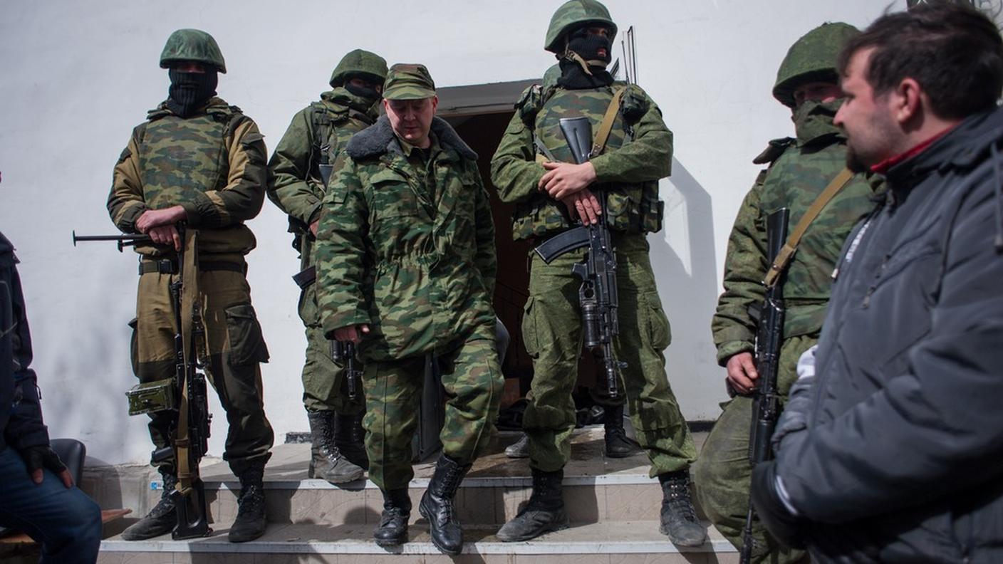 Miliziani filorussi fuori da una base militare ucraina in Crimea