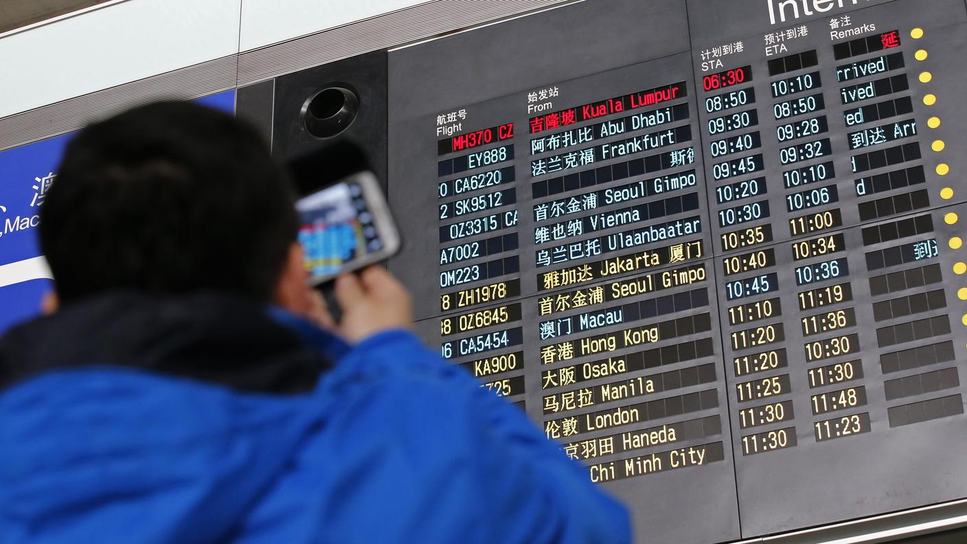 L'indicazione del volo MH370 in rosso sul tabellone dell'aeroporto di Pechino