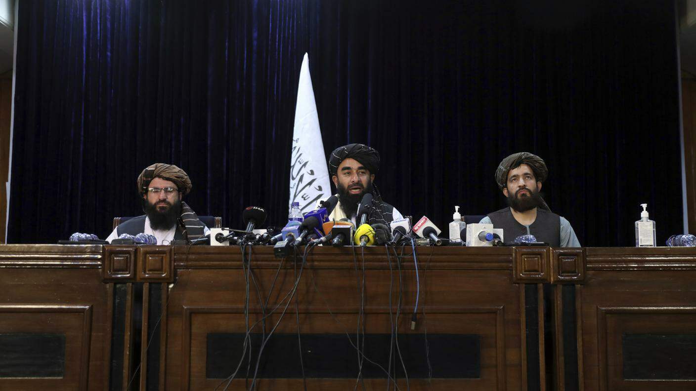 Il portavoce dei talebani, Zabihullah Mujahid (al centro), durante la prima conferenza stampa
