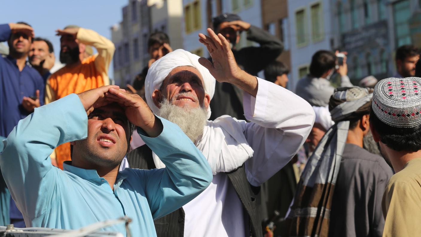 Cittadini di Herat osservano i corpi appesi in piazza dai talebani