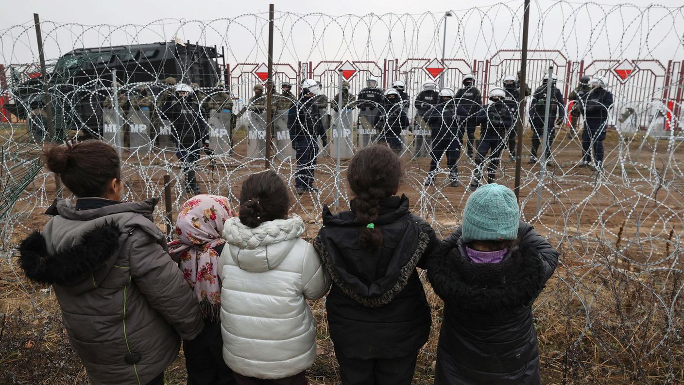 Bielorussia: bimbi migranti guardano, attraverso il filo spinato, le guardie polacche