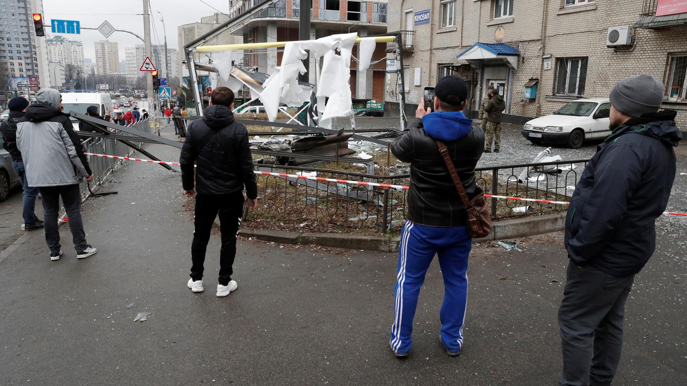 La gente per strada fotografa un missile che ha colpito Kiev