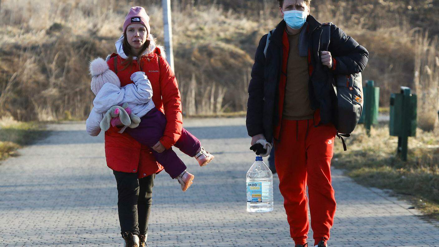 La fuga: due adulti ed un bimbo attraversano la frontiera tra Ucraina e Polonia