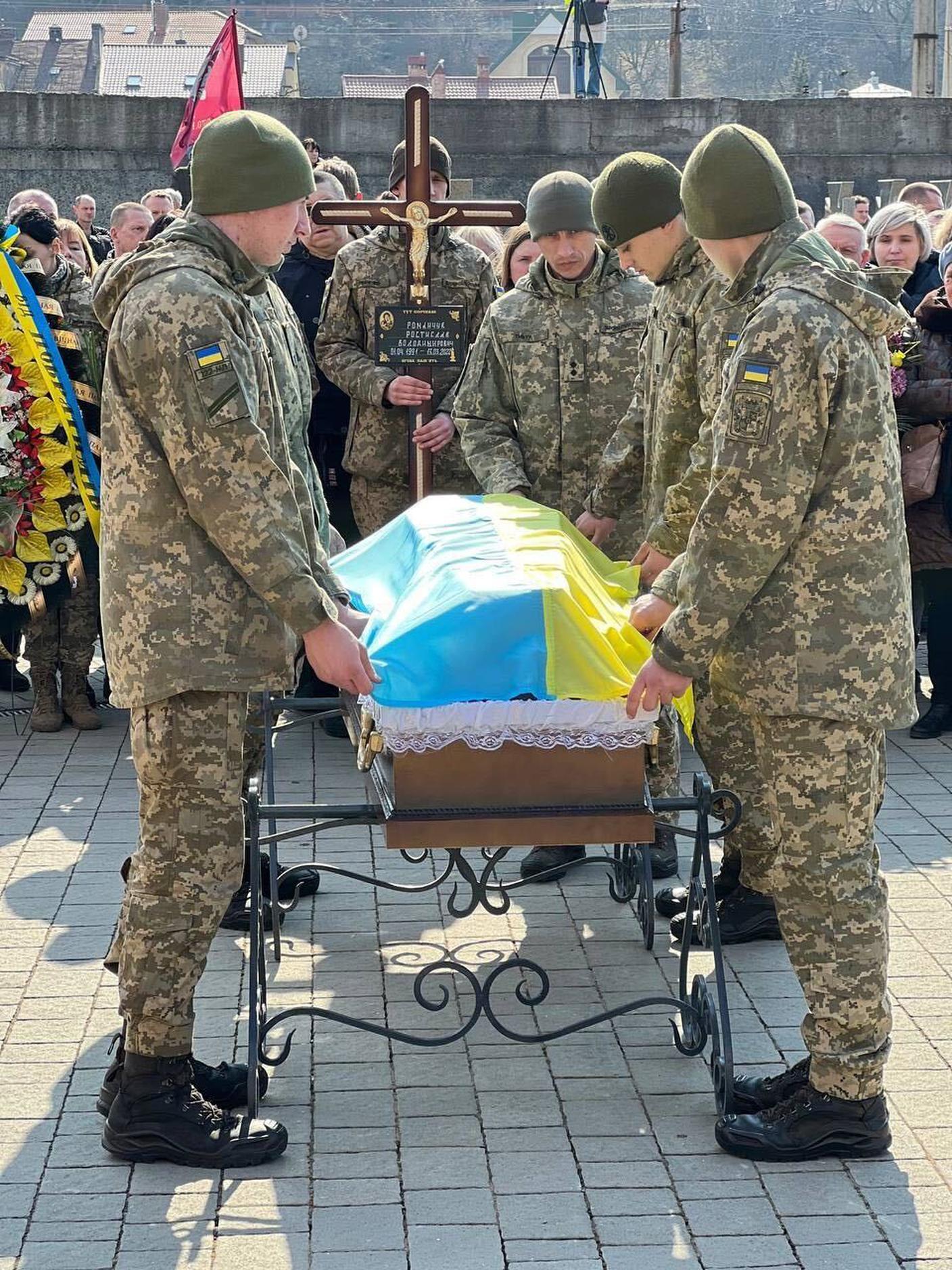 Soldati ucraini intorno alla bara di uno dei 4 ufficiali rimasti uccisi nel bombardamento di Yavoriv