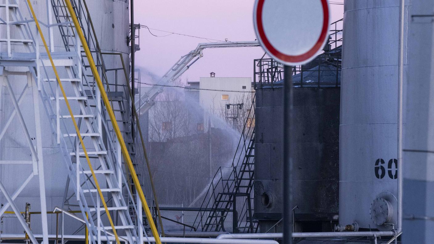 I pompieri al lavoro domenica mattina nel deposito di carburanti bombardato dai russi a Leopoli