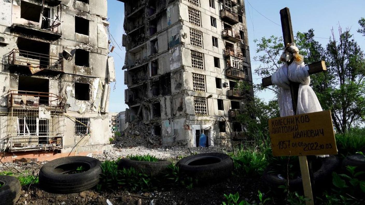 Una tomba davanti a un edificio residenziale devastato dai russi in un'area da loro occupata