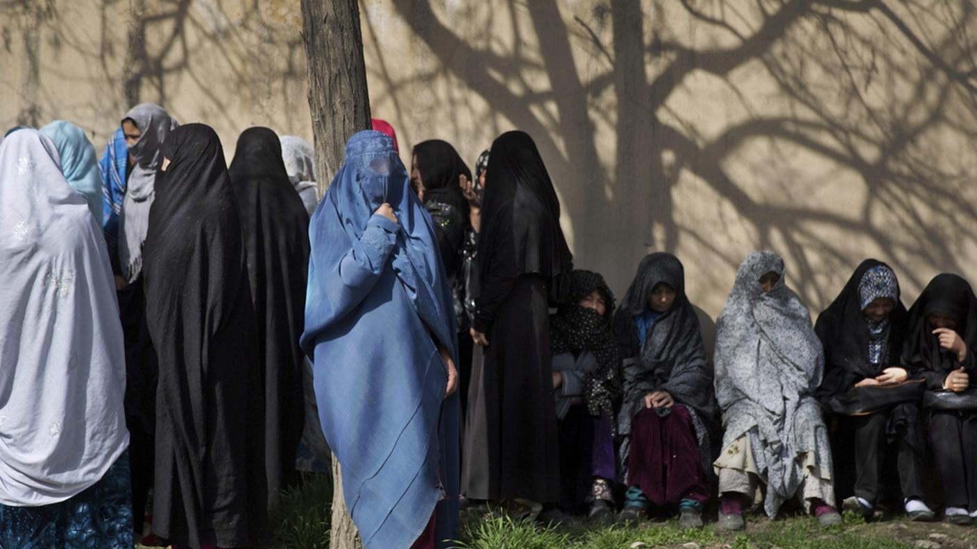 Donne in fila per ricevere la carta di elettrici