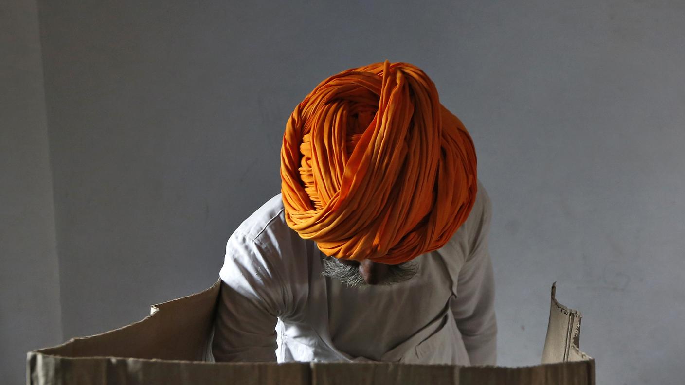 Un uomo con il suo turbante sta votando in un seggio nell'est del paese