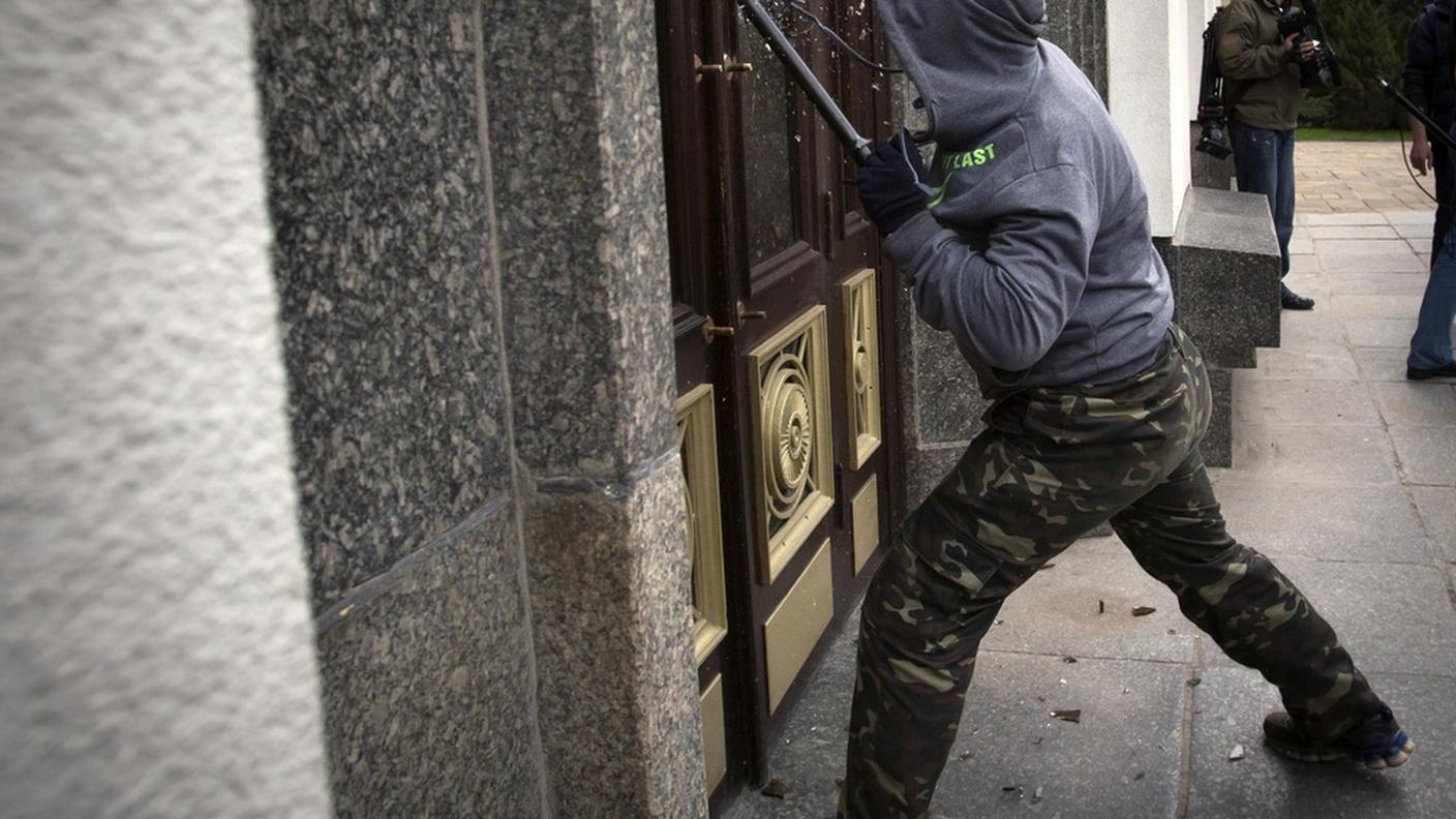 Un filorusso in azione durante l'occupazione di ieri a Lugansk
