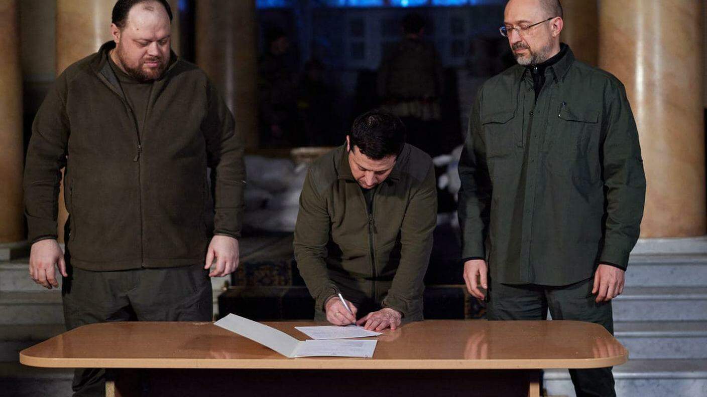 Volodymyr Zelensky con il presidente del Parlamento Ruslan Stefanchuk e il premier Denys Shmyhal alla firma in febbraio del documento con cui Kiev chiedeva di aderire all'UE