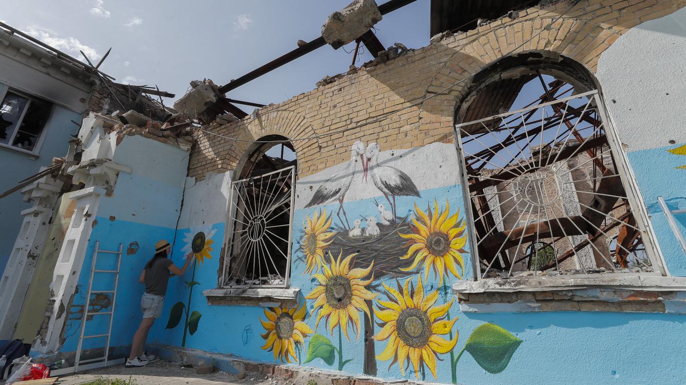 La street artist Olena Yanko dipinge un muro di Kiev bombardato dai russi con i colori dell'Ucraina