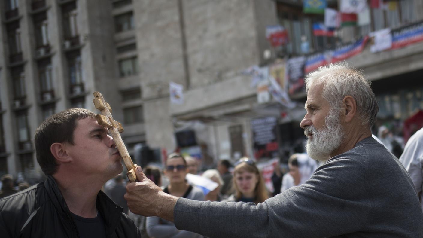 Un prete ortodosso benedice un ragazzo domenica a Odessa