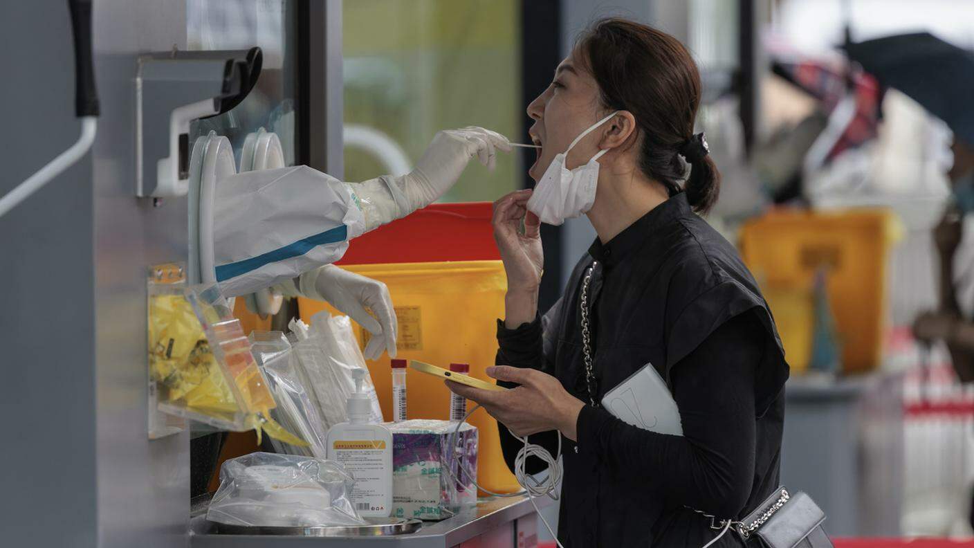 Una donna cinese si sottopone al test anti-Covid per strada (foto d'archivio)