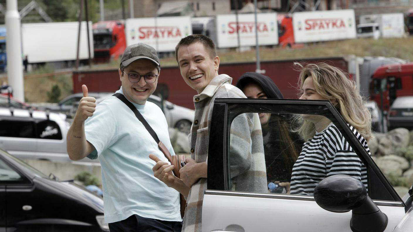 Due ragazzi russi felici dopo aver passato il confine con la Georgia domenica