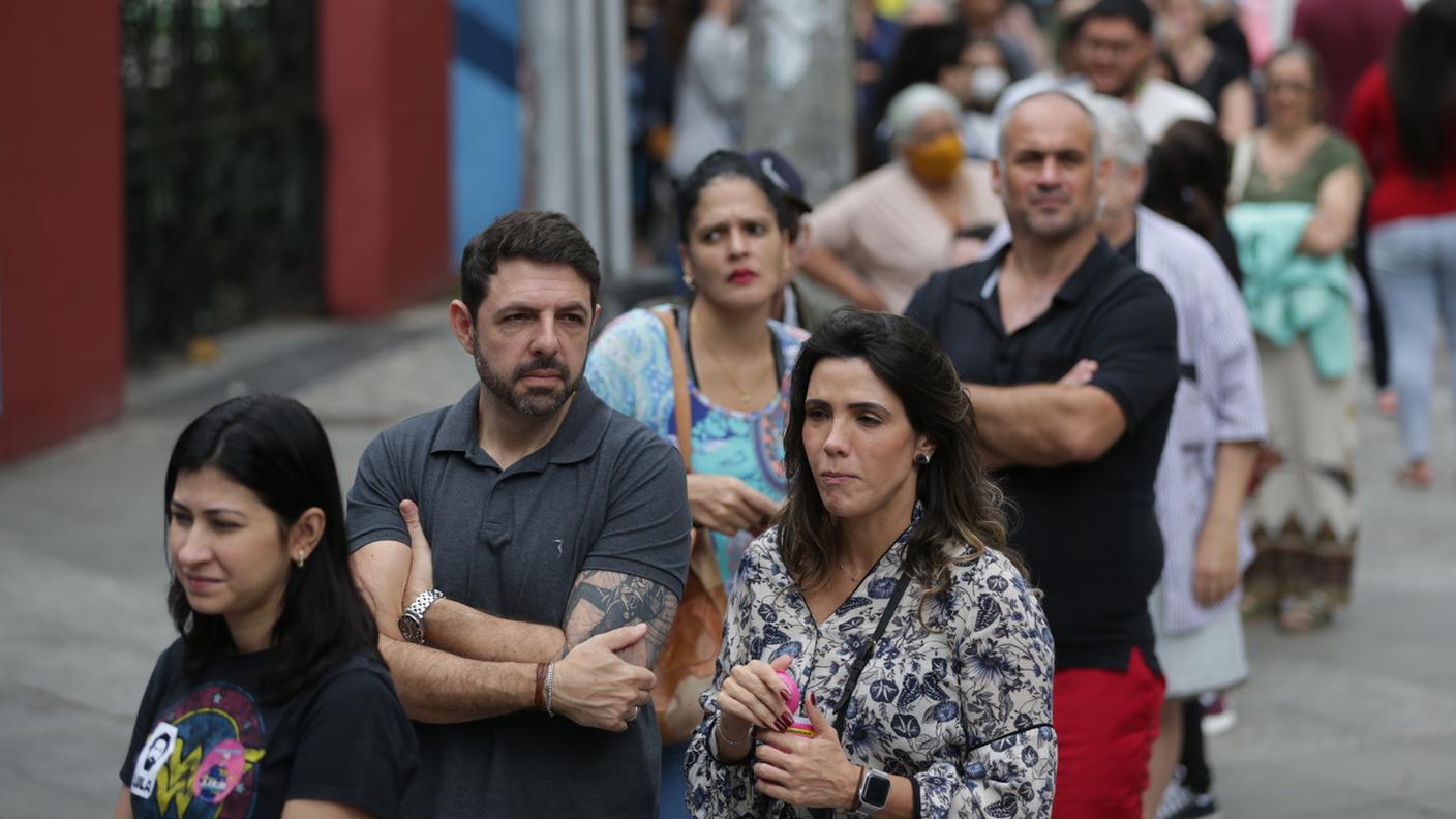 Elettori in fila davanti a un seggio a Rio de Janeiro