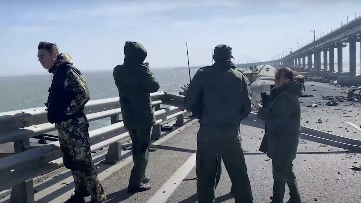 Investigatori russi sul luogo dell'esplosione. Si vede il tratto stradale crollato