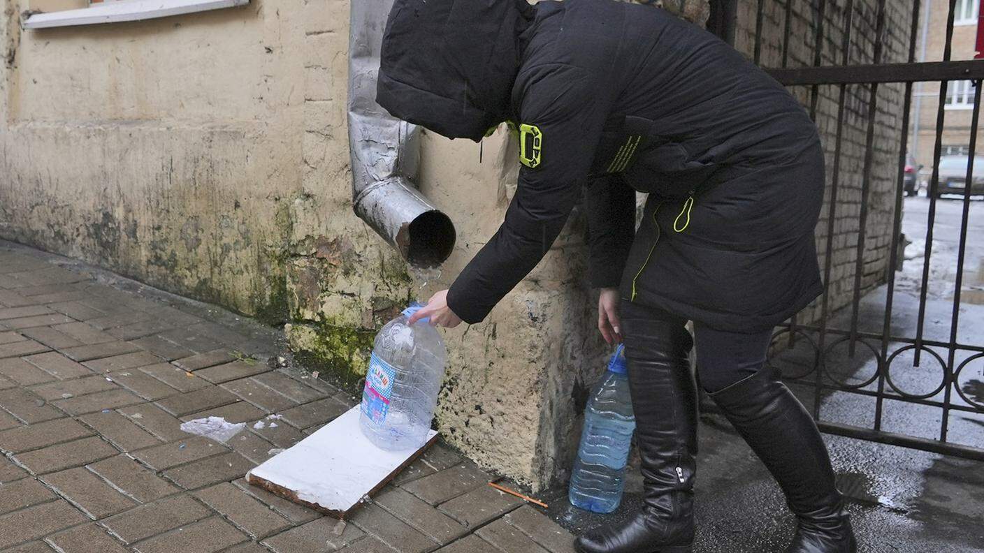 Kiev senza approvvigionamenti idrici: una donna ripresa oggi mentre cercava di raccogliere l'acqua da una grondaia