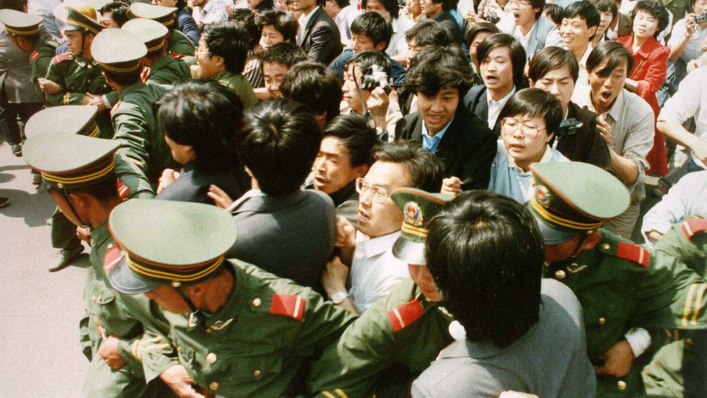 1989: gli studenti forzano il cordone della polizia per entrare inpiazza