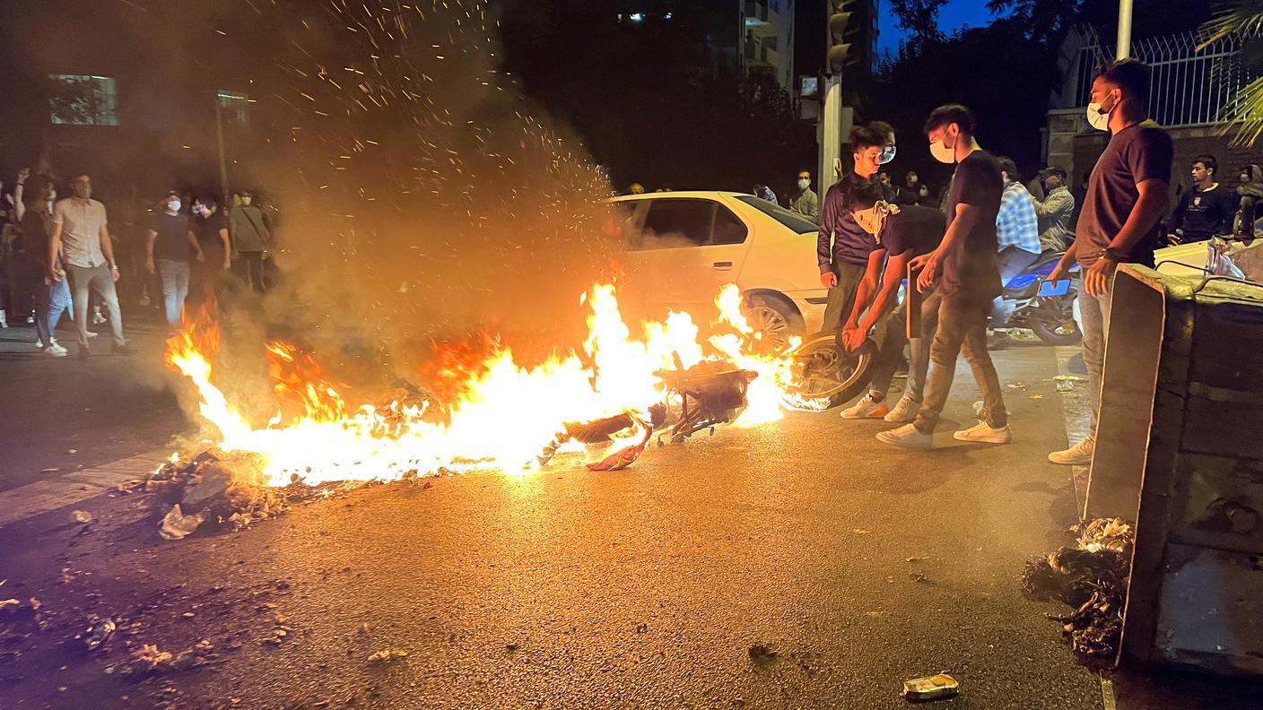 Una motocicletta della polizia data alle fiamme durante alcuni moti esplosi in piazza a Teheran a novembre
