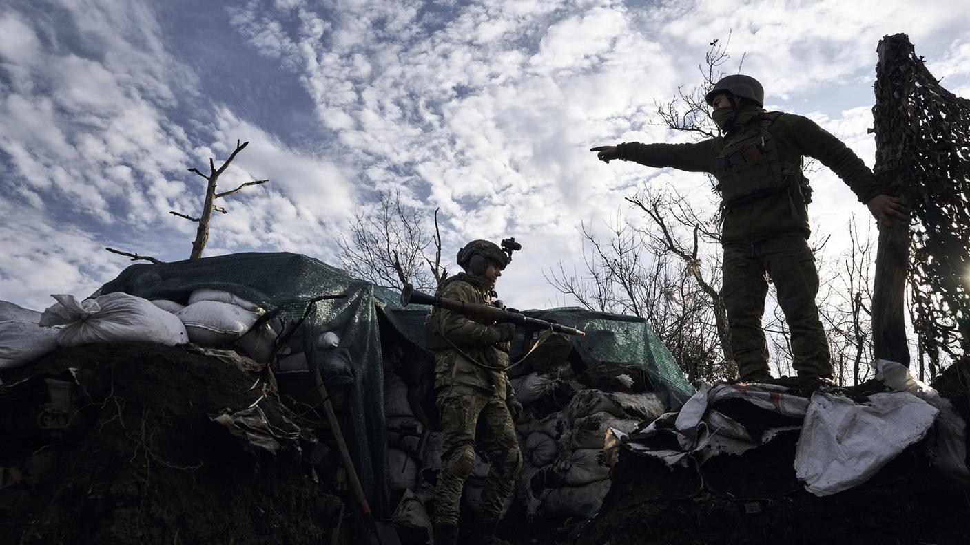 Due militi ucraini si preparano al combattimento in una zona di guerra nel Donbass