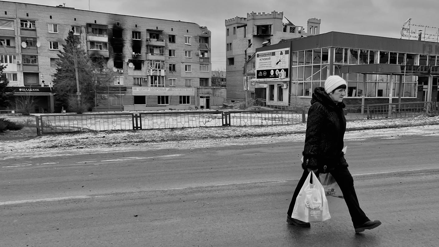 Una donna che cammina per strada a Izium