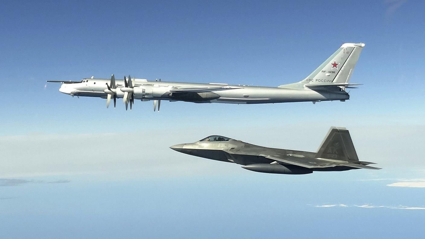 Un bombardiere russo Tu-95, in alto, intercettato da un caccia F-22 Raptor USA al largo dell'Alaska. Era il 16 giugno 2020