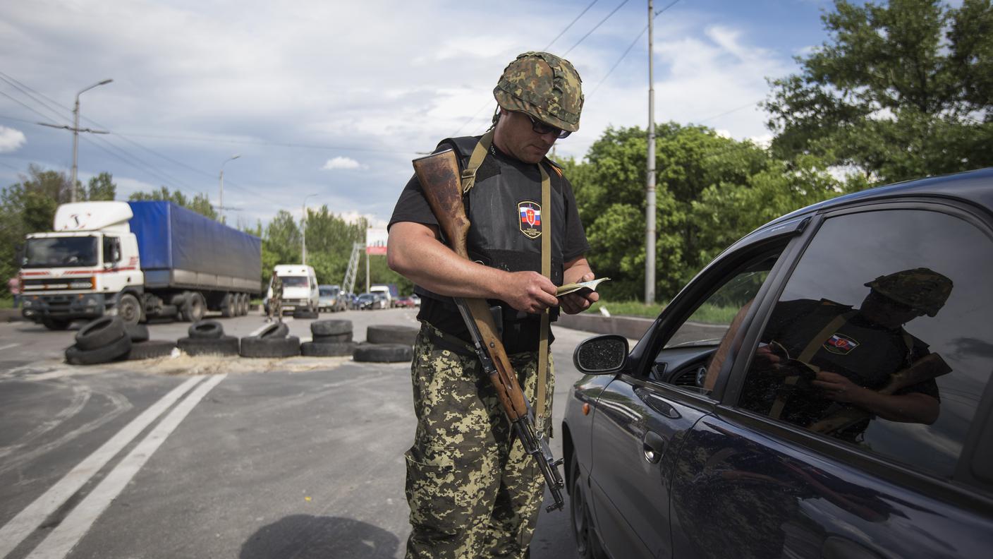 Un miliziano filorusso a un posto di blocco di Donetsk