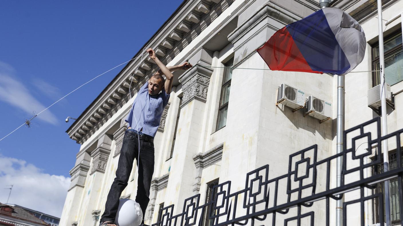 Un manifestante strappa la bandiera dell'ambasciata russa a Kiev