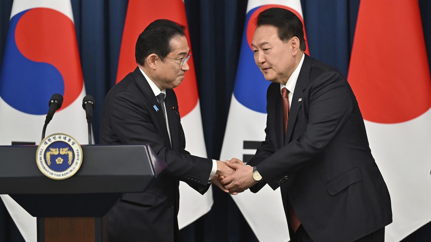 La stretta di mano tra il premier giapponese Kishida ed il presidente sudcoreano Yoon