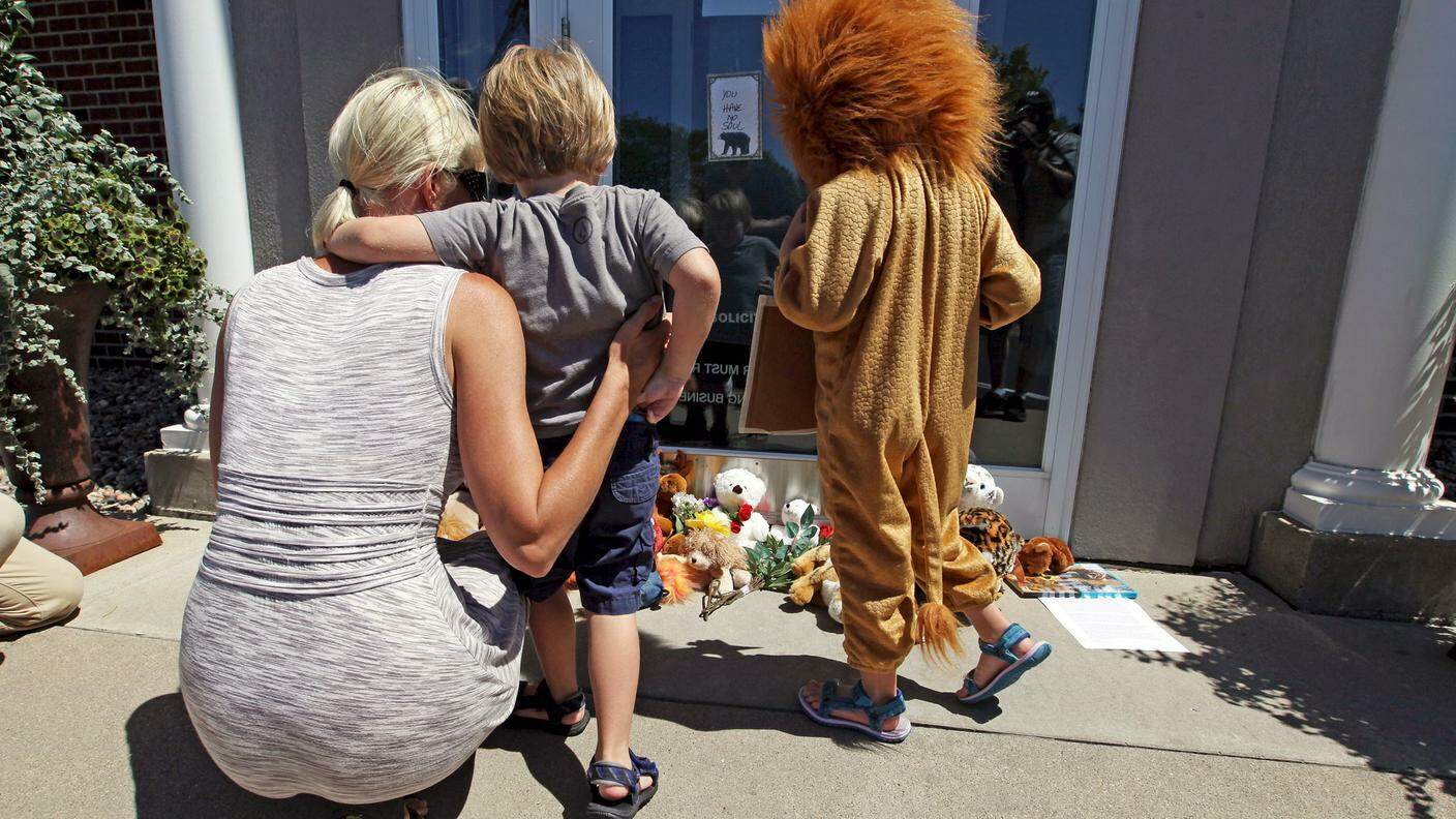 Una mamma con i figli davanti allo studio del dottor Palmer; uno è travestito da leone