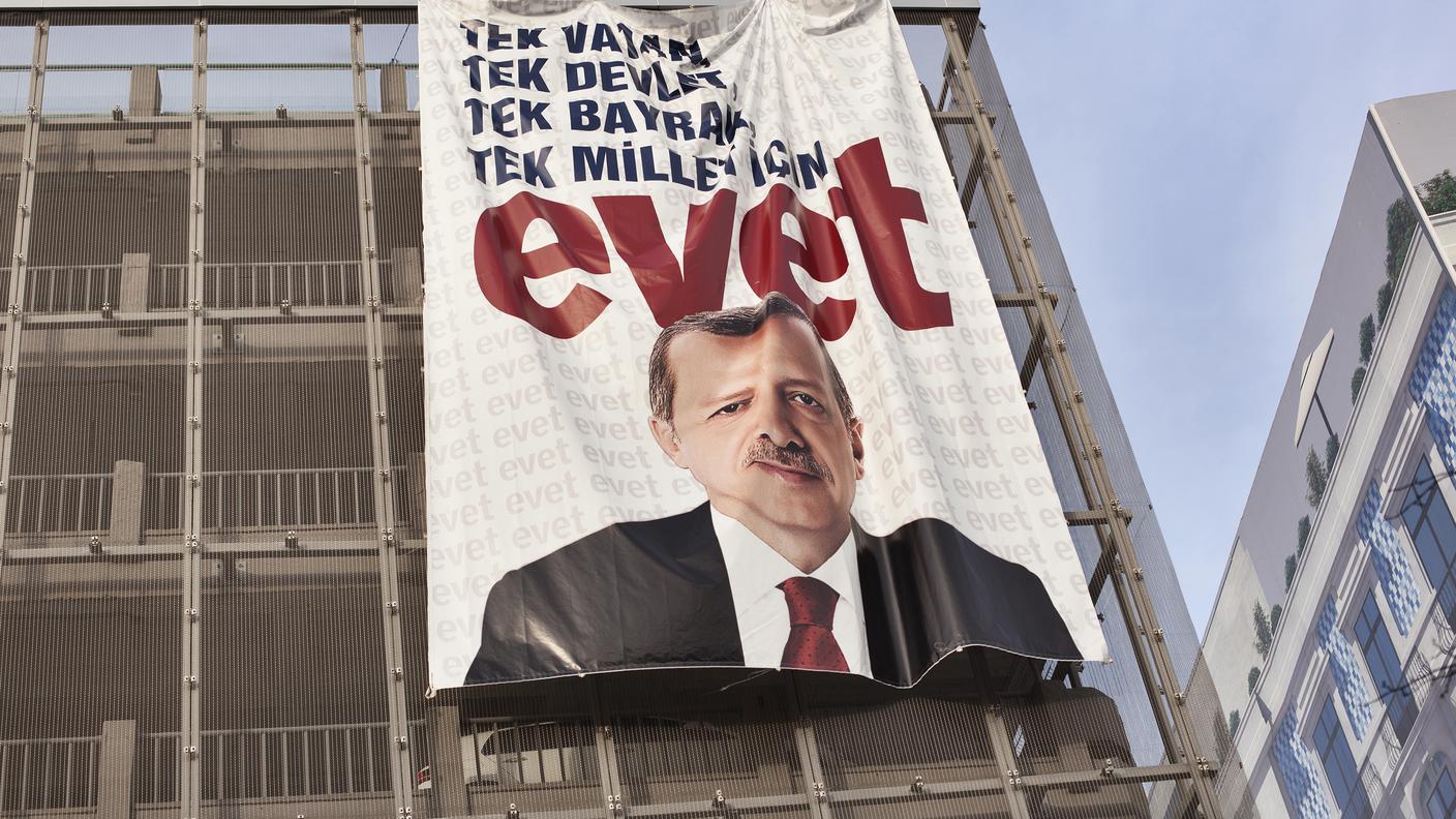 Turchia, vigilia del referendum costituzionale 2017 per il presidenzialismo. Strade e edifici di Istanbul si sono riempiti di enormi ritratti di Recep Tayyip Erdoğan.Qui siamo sempre a Karaköy, sul lato europeo. La gigantografia del leader, corrugata dalle piege del tessuto, è stata collocata all'esterno di un parcheggio a più piani.
