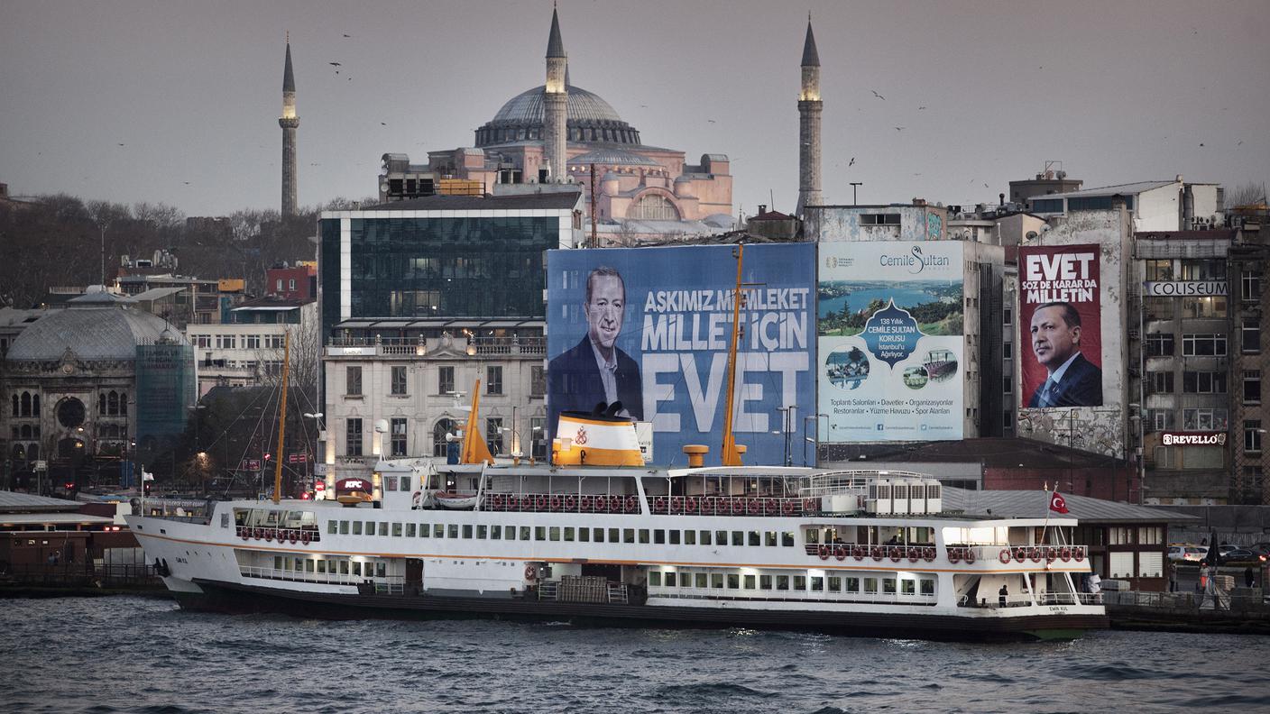 Turchia, vigilia del referendum costituzionale 2017 per il presidenzialismo. Strade e edifici di Istanbul si sono riempiti di enormi ritratti di Recep Tayyip Erdoğan.Qui siamo a Eminönü, sul lato europeo. In primo piano uno dei tanti traghetti pubblici che quotidianamente fanno la spola tra i due lati del Bosforo. Sullo sfondo si staglia imponente la basilica di Santa Sofia.