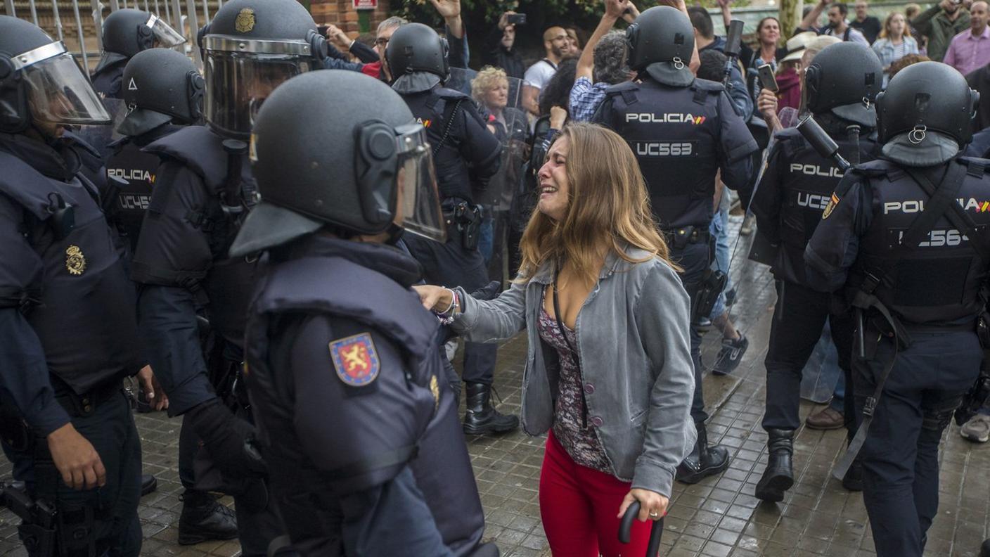 Una giovane piange davanti alla polizia, la Catalogna è ferita