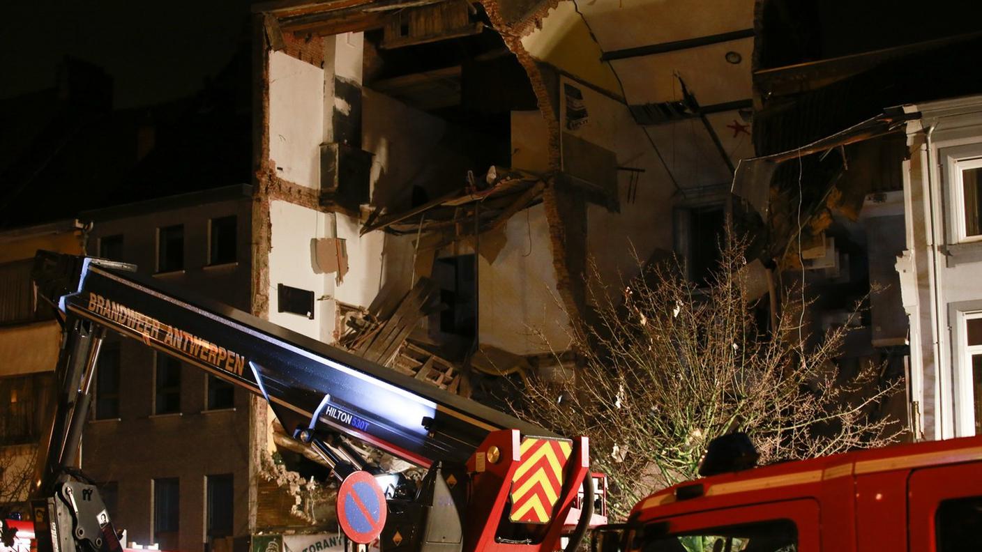 I pompieri all'opera davanti all'edificio sventrato dallo scoppio di lunedì sera