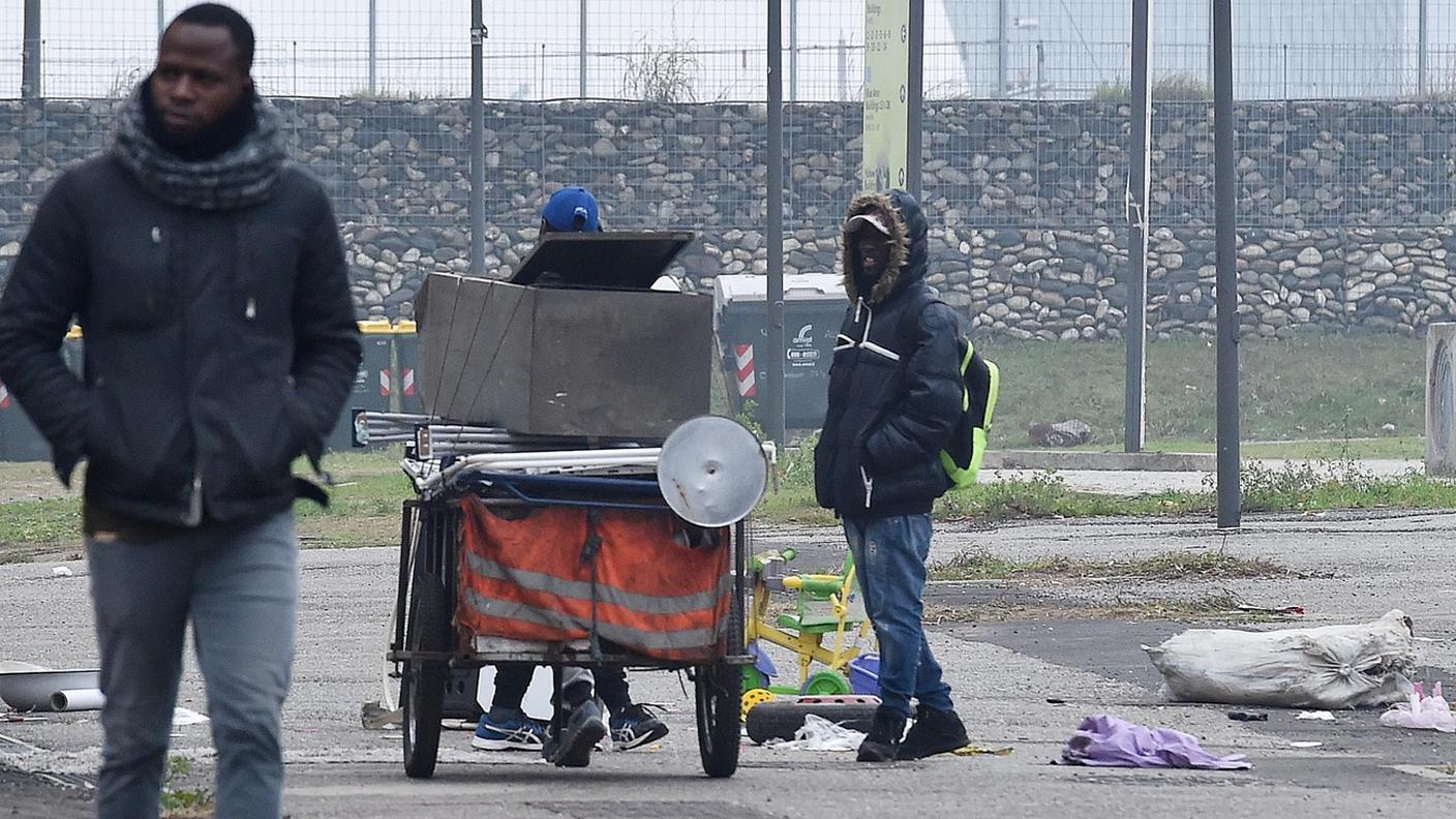 Alcuni migranti passeggiano nel cortile dell'ex villaggio olimpico di Torino