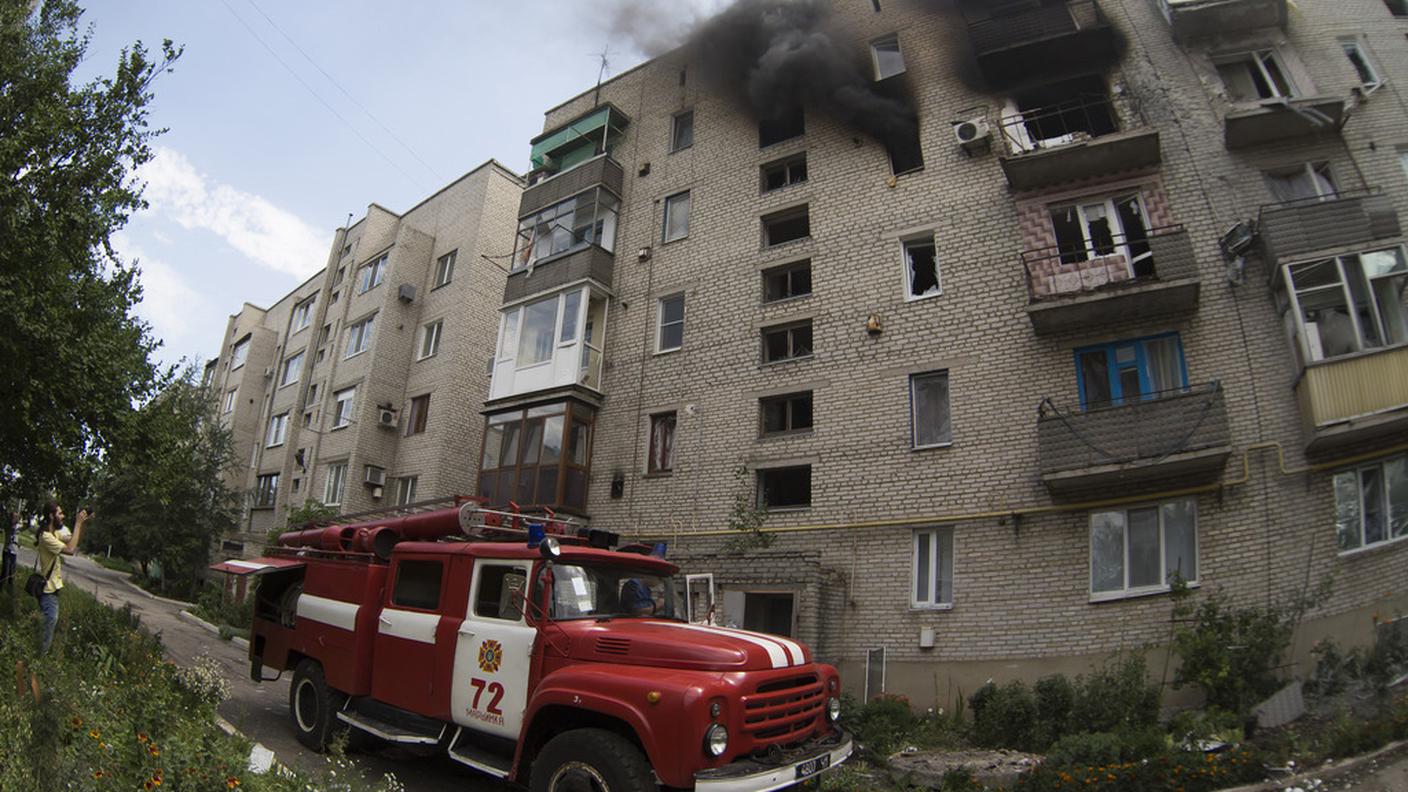 I pompieri sul posto dell'incendio di un palazzo centrato da missili a Donetsk