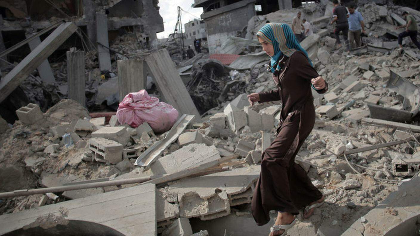 Una giovane palestinese fra le macerie della sua casa a Gaza
