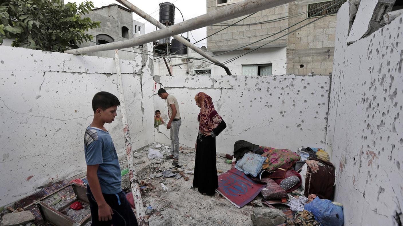 Una famiglia torna a ispezionare la casa distrutta dai bombardamenti a Jebaliya
