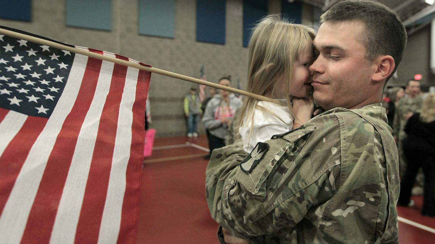 Un soldato americano rientrato da una missione abbraccia la figlia