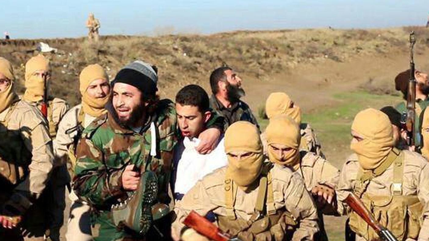 Militanti dell'IS con il pilota giordano ucciso