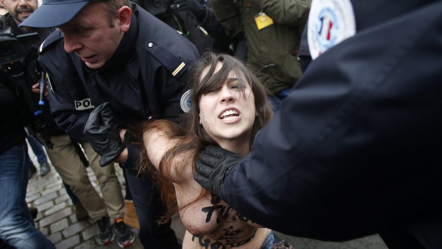Una delle Femen immobilizzata dagli agenti