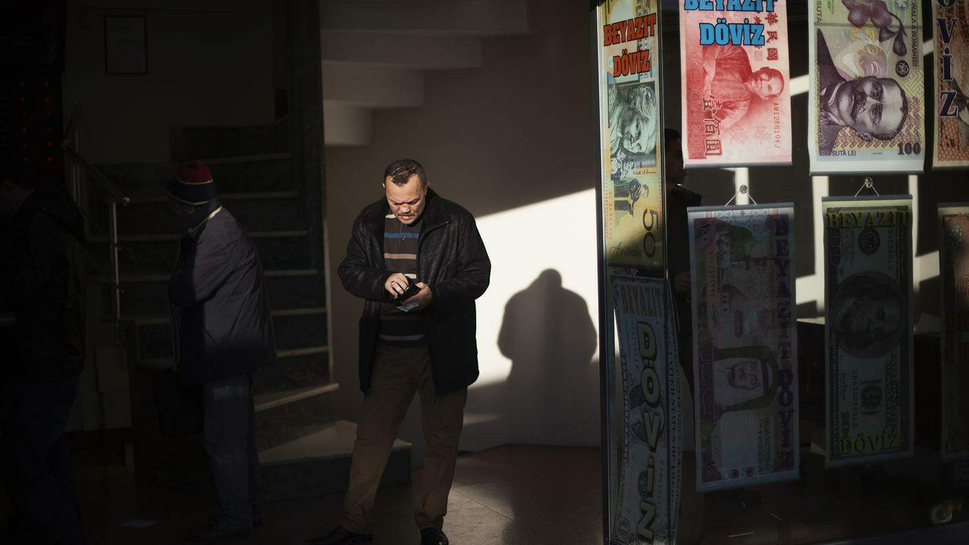Nel distretto di Fatih (Istanbul), un uomo, in coda ad un cambio valuta, conta il propriodenaro