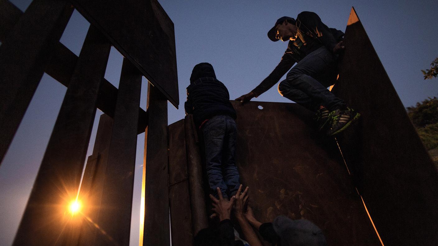 Migranti centroamericani, in maggioranza Honduregni, scavalcano il muro di confine fra Messico e US per chiedere asilo alle autorità americane, Tijuana, Messico, Dicembre 2018.
