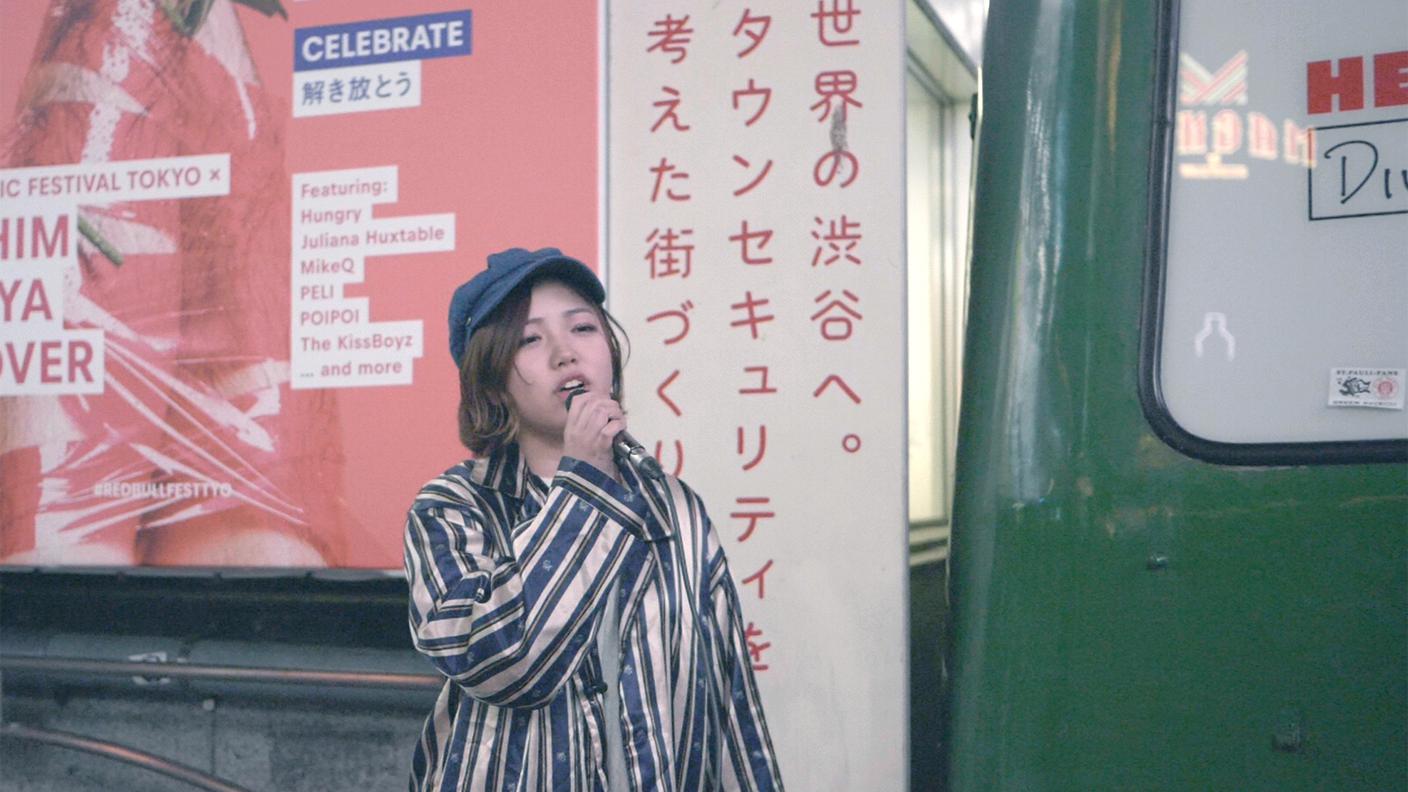 Una ragazza si esibisce tra le strade di Tokyo