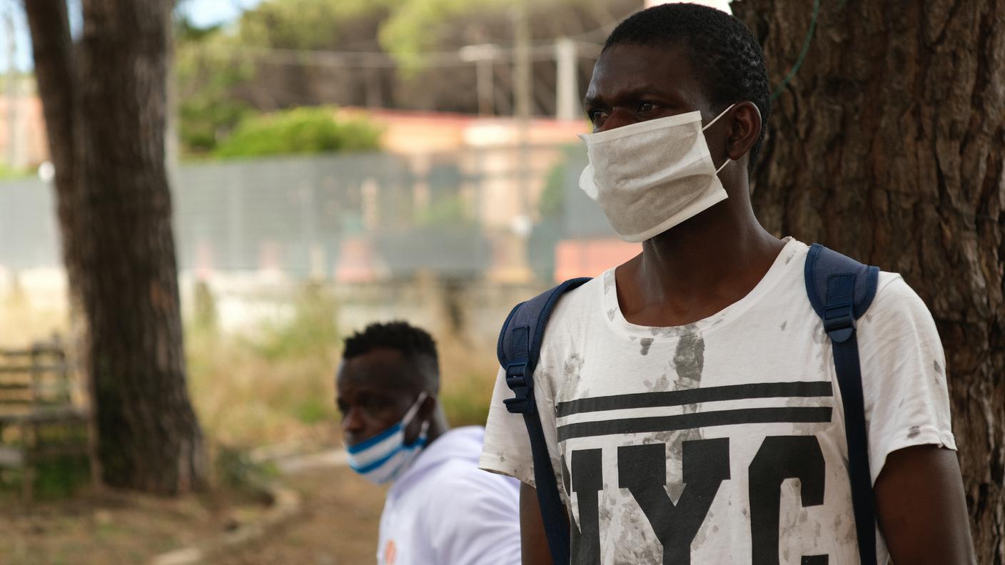 Un ragazzo senegalese aspetta all’esterno del centro Fernandes di Castel Volturno il proprio turno per chiedere informazioni sulla sanatoria uscita a giugno