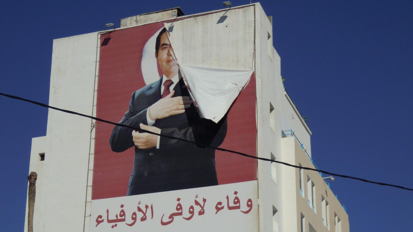 Una gigantografia dell'ex presidente Zine El-Abidine Ben Ali, strappata via