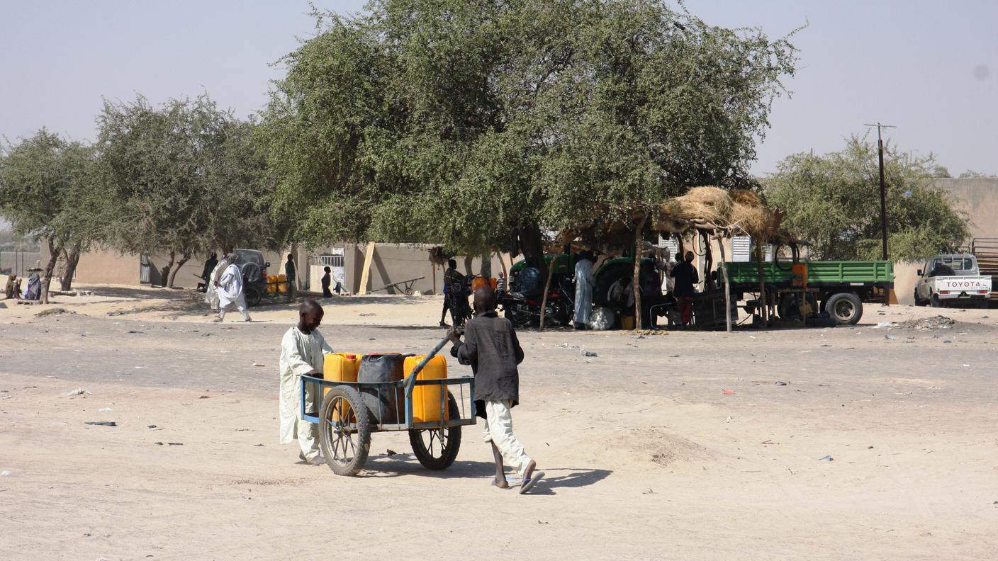 Ragazzi ciadiani trasportano bidoni d'acqua in un campo profughi in Niger